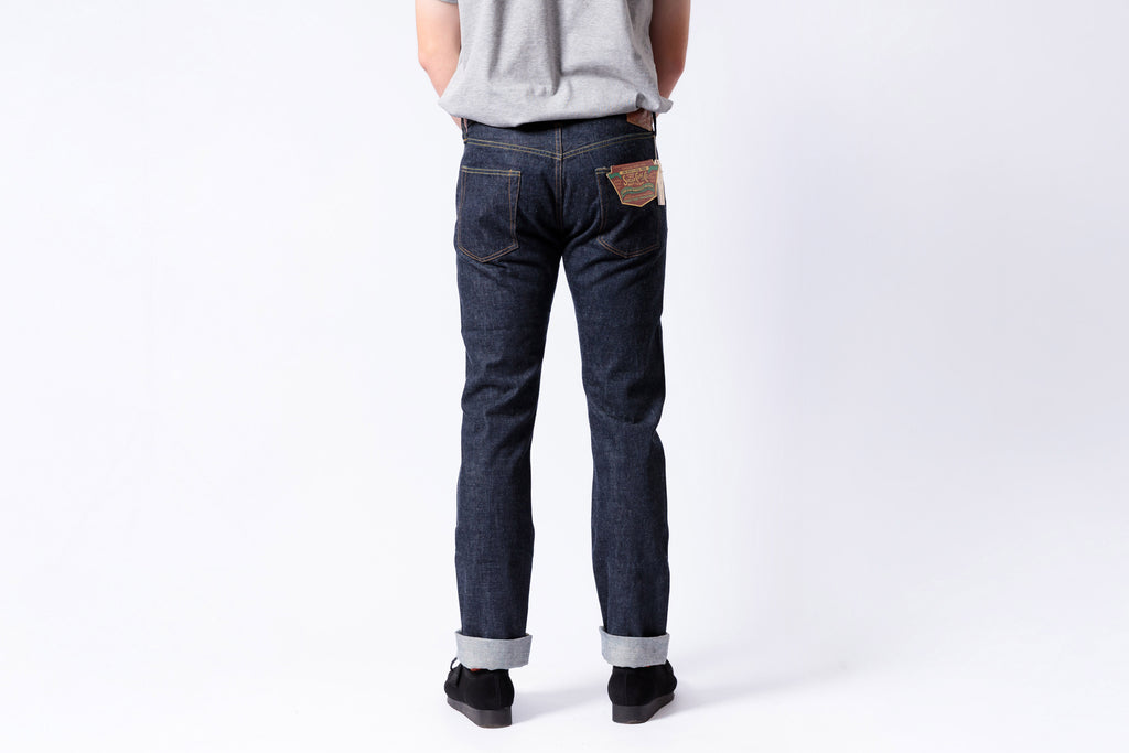 Person wearing dark blue jeans on a white background