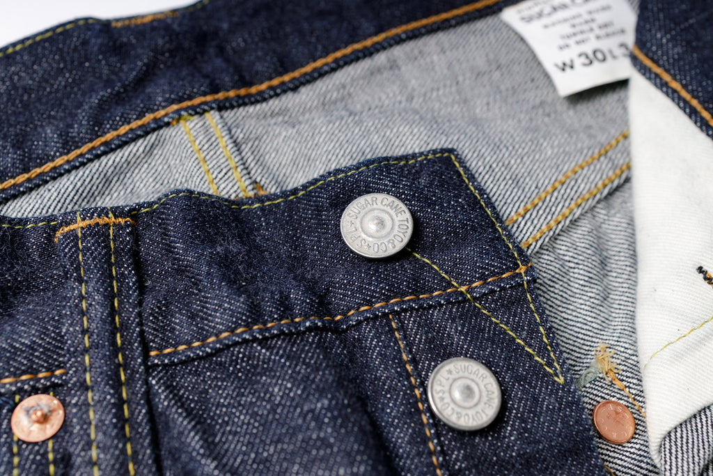 Close-up of a denim jacket with buttons and a brand label.