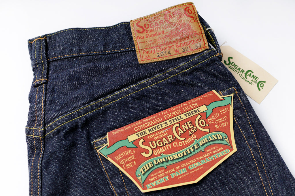 Denim jeans with a prominent brand label on a white background