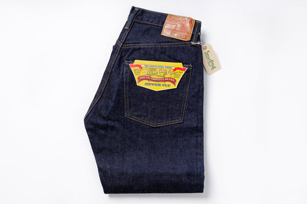 Pair of dark blue jeans with a brand label on a white background