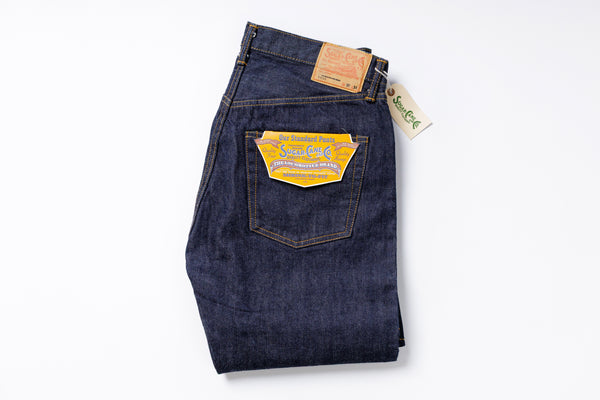 Folded pair of blue jeans with a visible brand tag on a white background