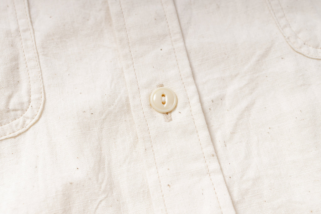 Close-up of a white button on a textured fabric background