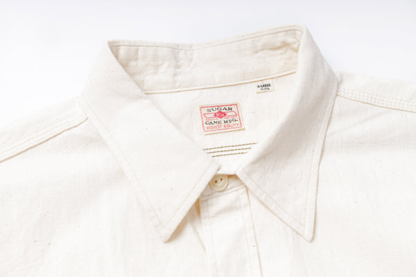 Close-up of a white shirt with a brand label on a white background