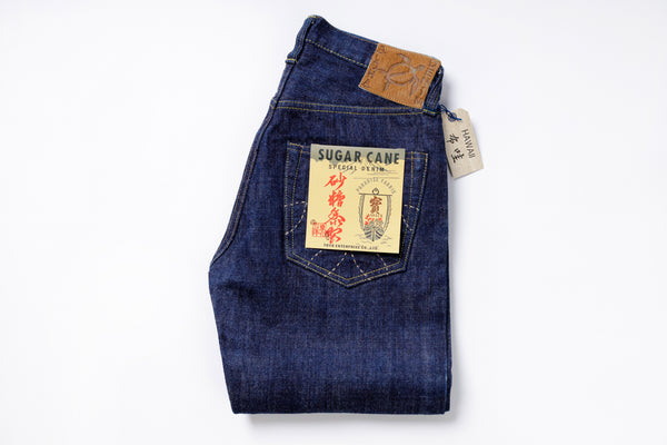 Folded pair of blue jeans with a tag on a white background