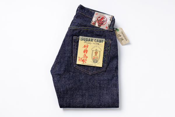 Folded pair of blue jeans with visible brand labels on a white background