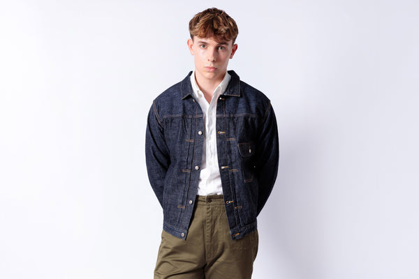 Man wearing a denim jacket and white shirt on a white background