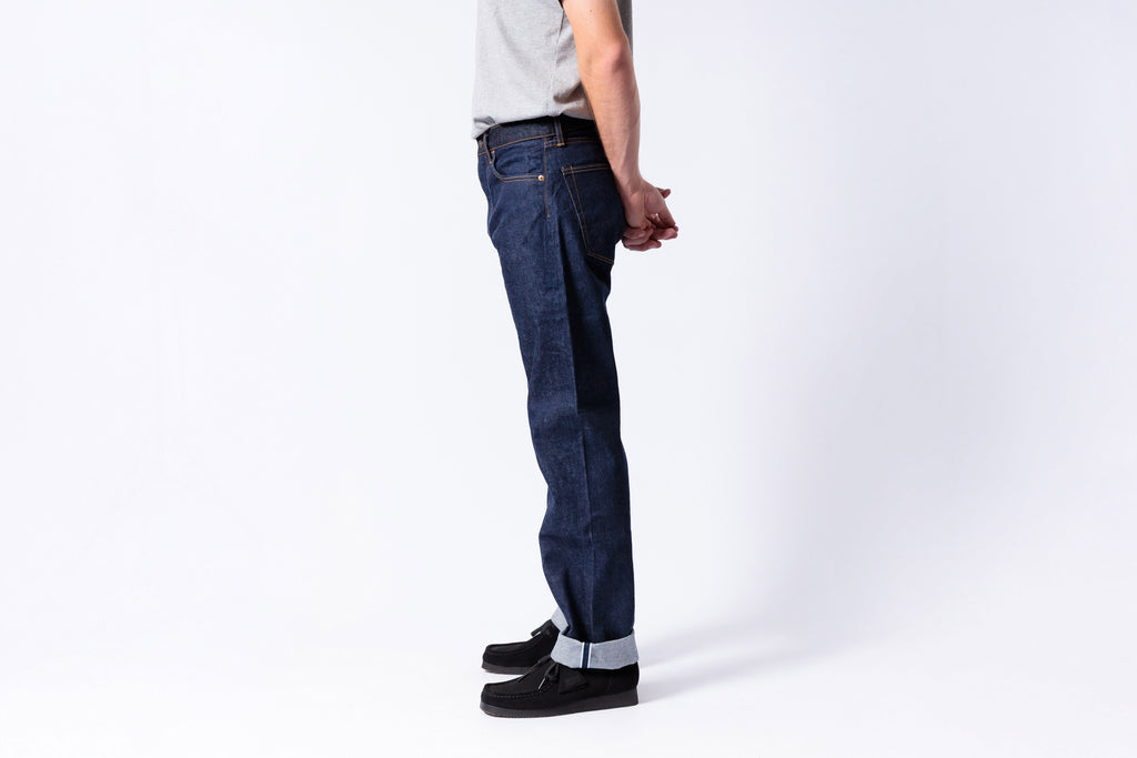 Person wearing dark blue jeans on a white background
