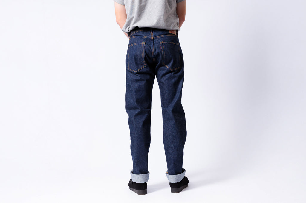 Person wearing blue jeans on a white background