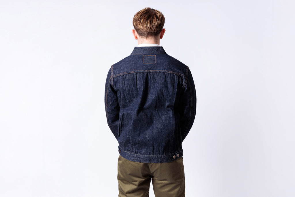 Man wearing a dark blue denim jacket on a white background