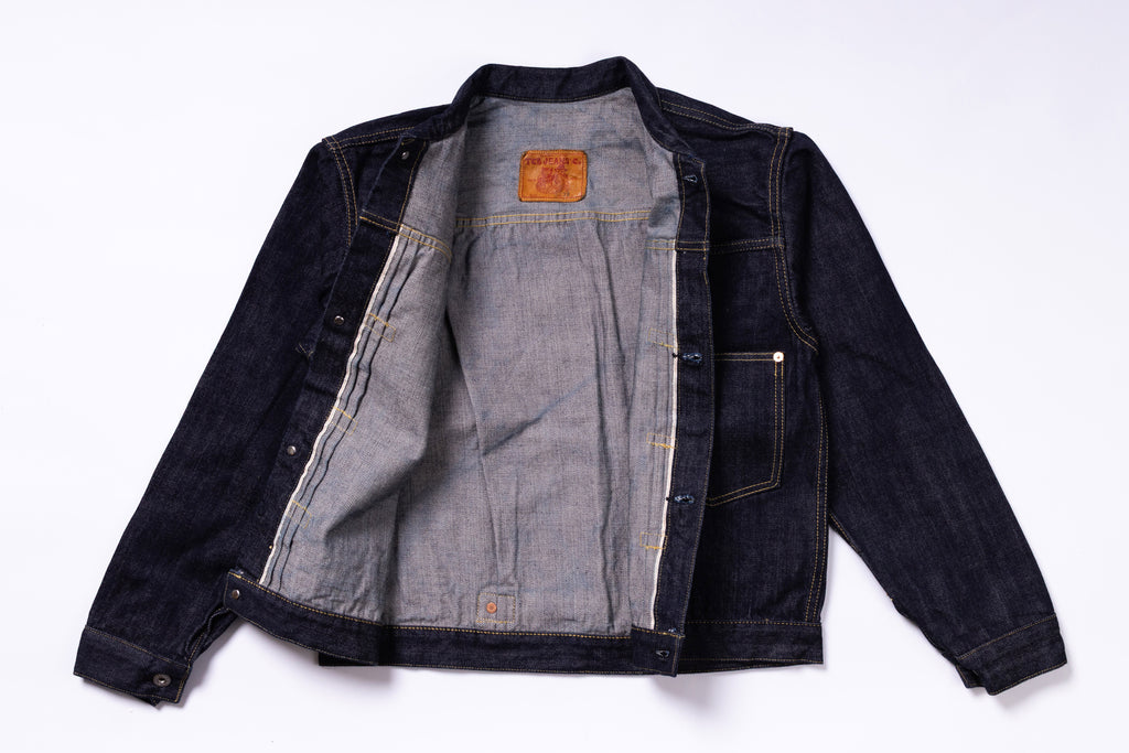 Denim jacket with a brand patch on a white background