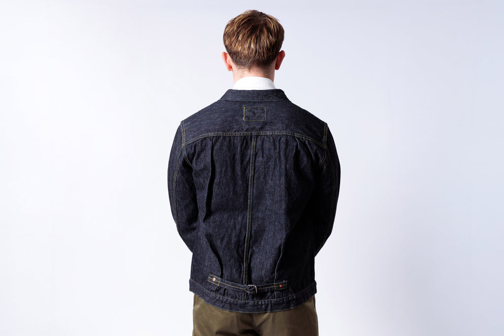 Person wearing a dark denim jacket on a white background