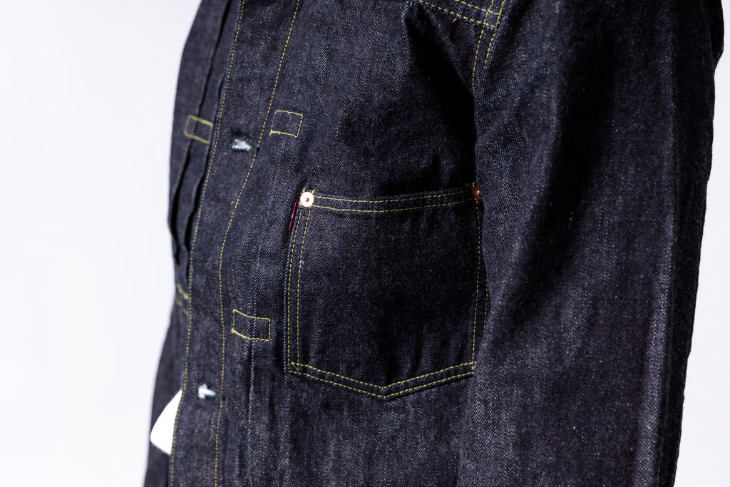 Dark denim jacket with visible stitching details on a white background