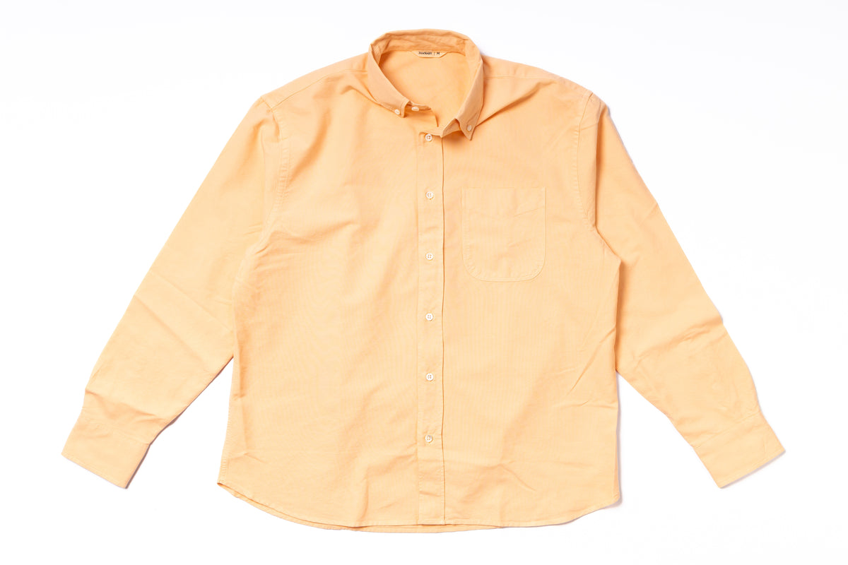 Orange shirt with collar and buttons on a white background