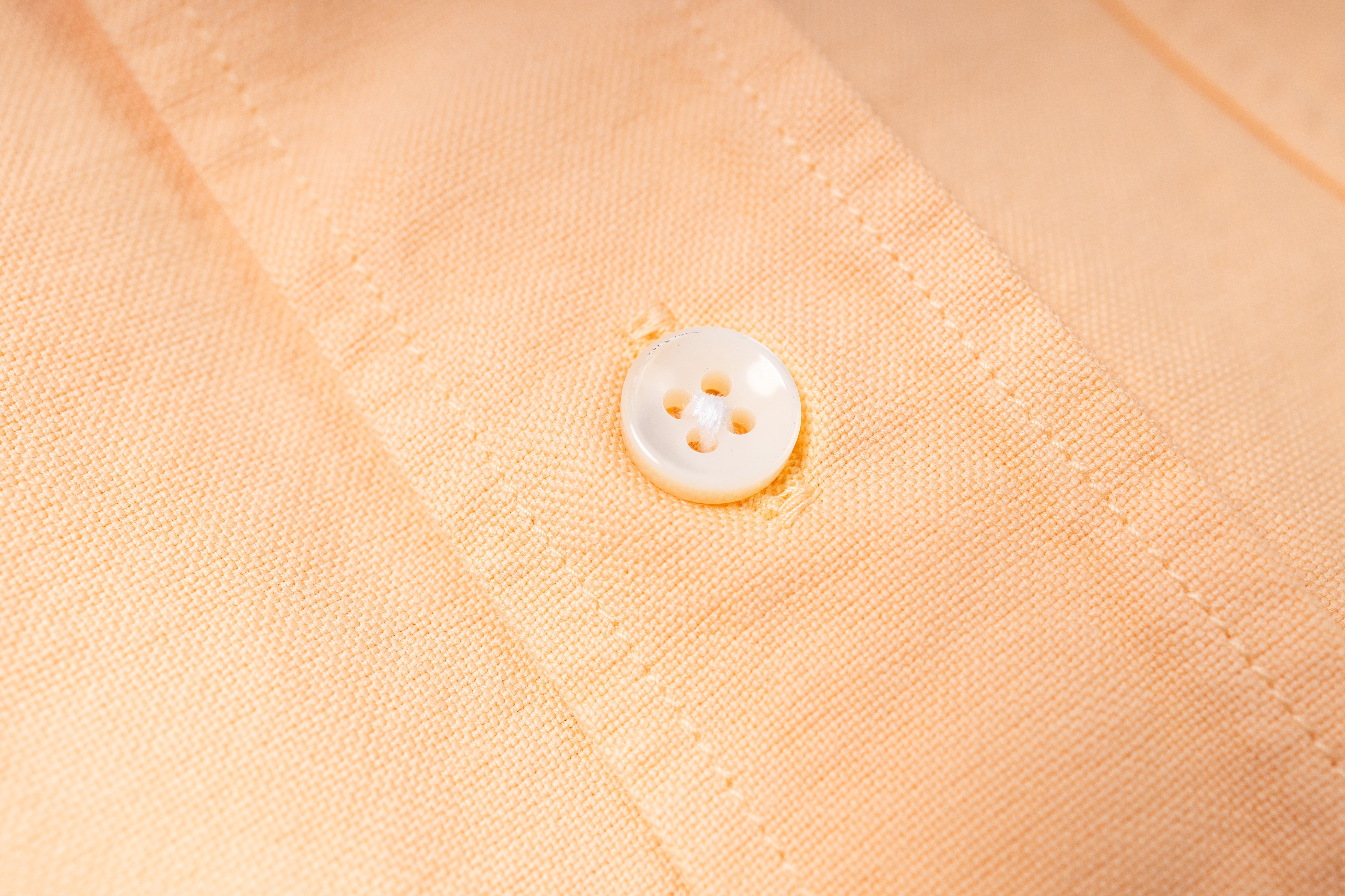 Close-up of a button on beige fabric
