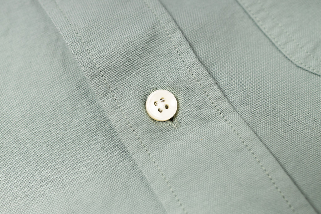 Close-up of a button on a light green shirt