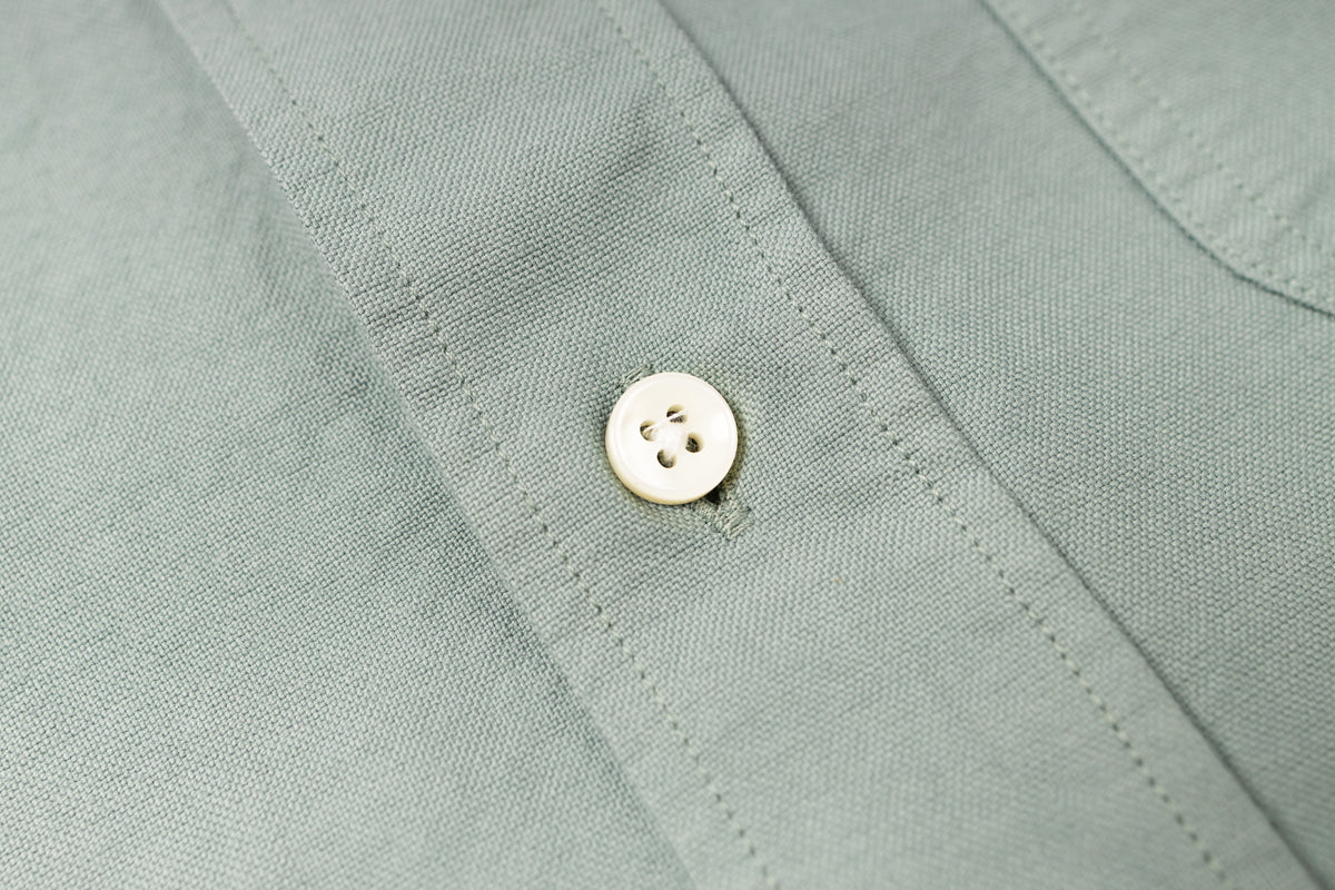 Close-up of a button on a light green shirt
