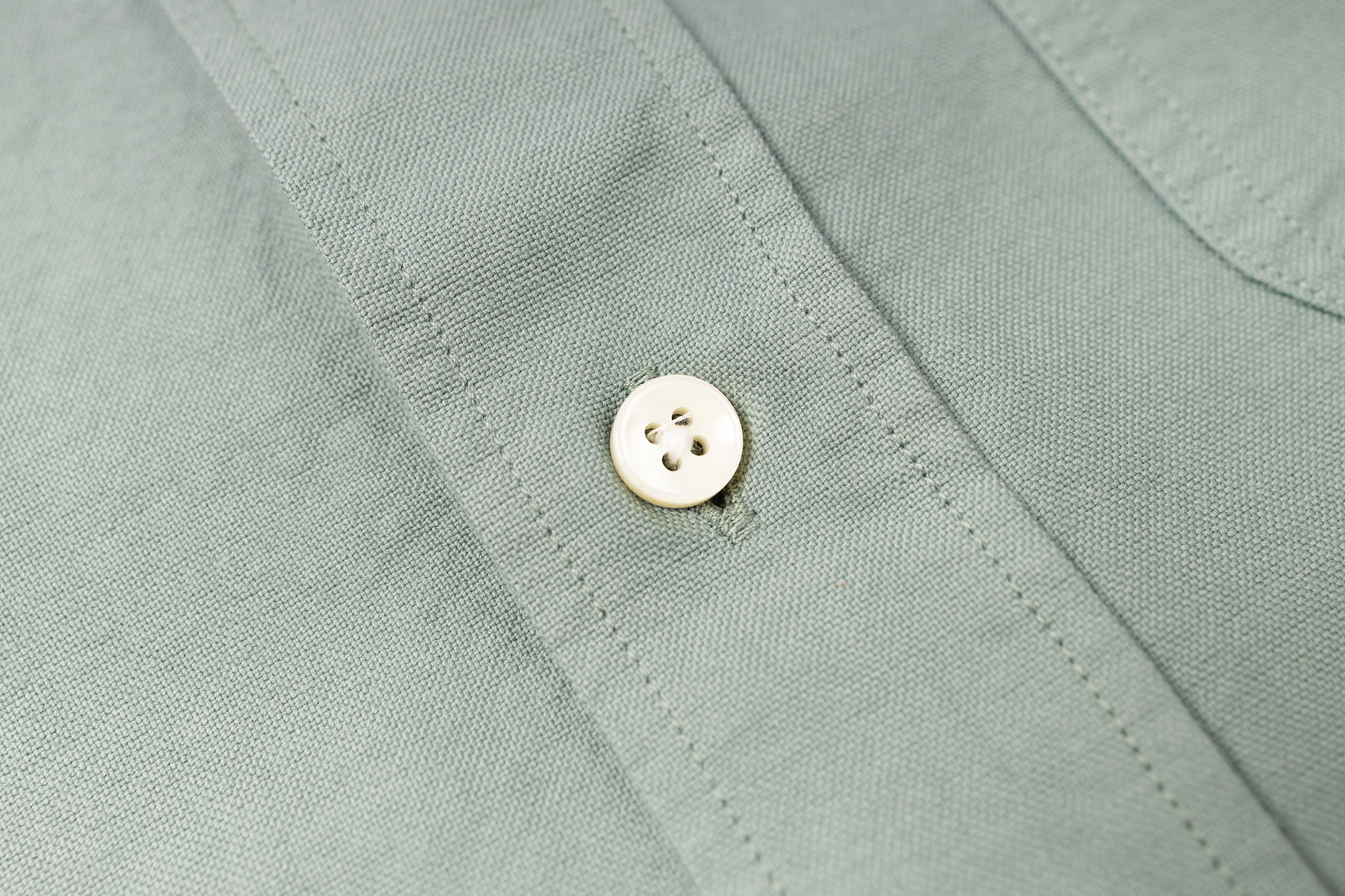 Close-up of a button on a light green shirt