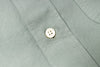 Close-up of a button on a light green shirt