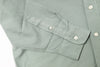 Close-up of a light gray shirt with button details on a white background