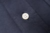 Close-up of a white button on navy blue fabric
