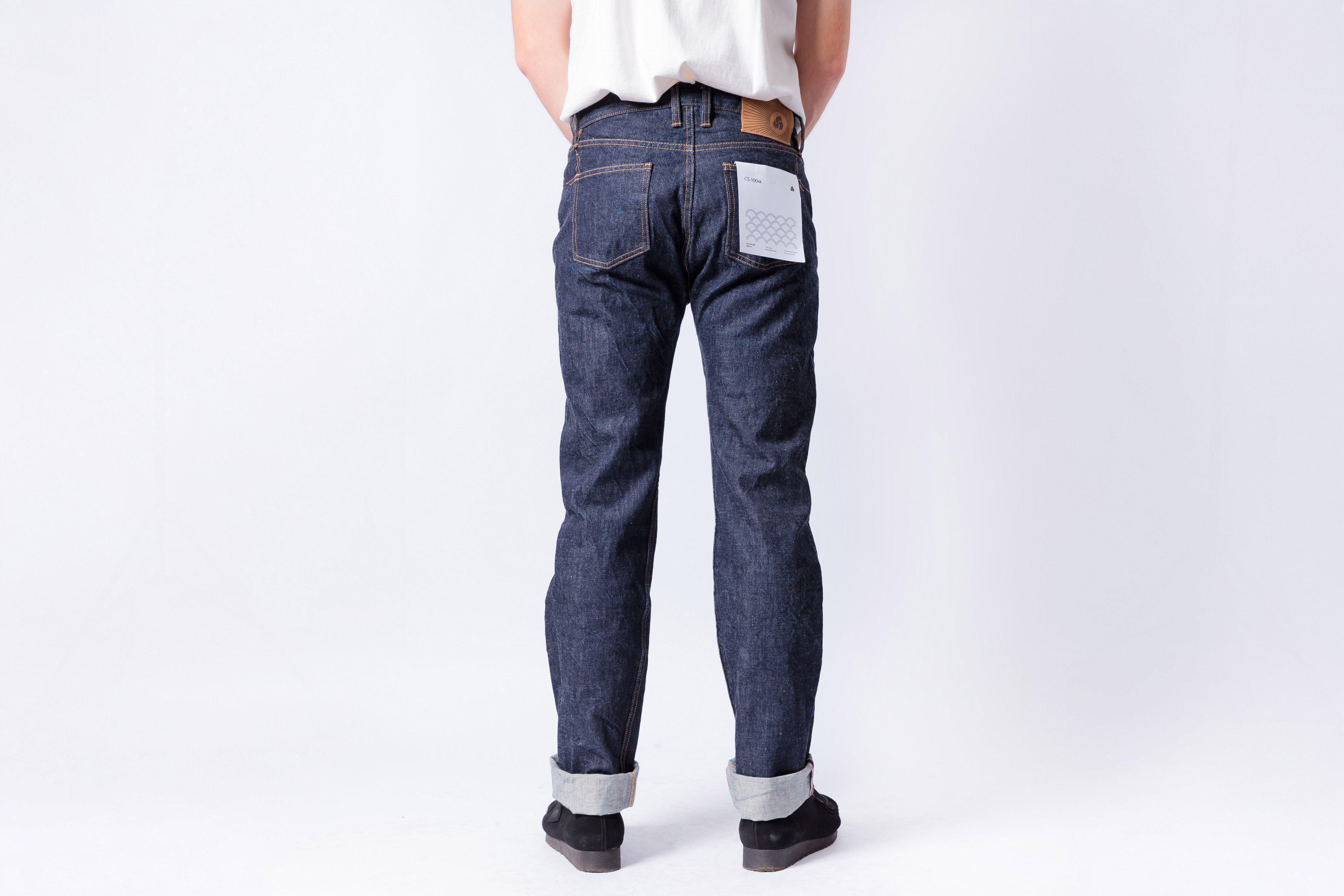 Person wearing blue jeans on a white background