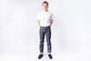 Person wearing a white t-shirt and dark jeans on a white background