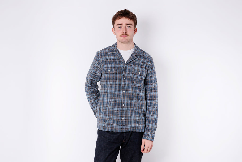 Man wearing a plaid shirt against a white background