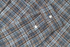 Close-up of a plaid fabric with a checkered pattern in blue and brown tones.