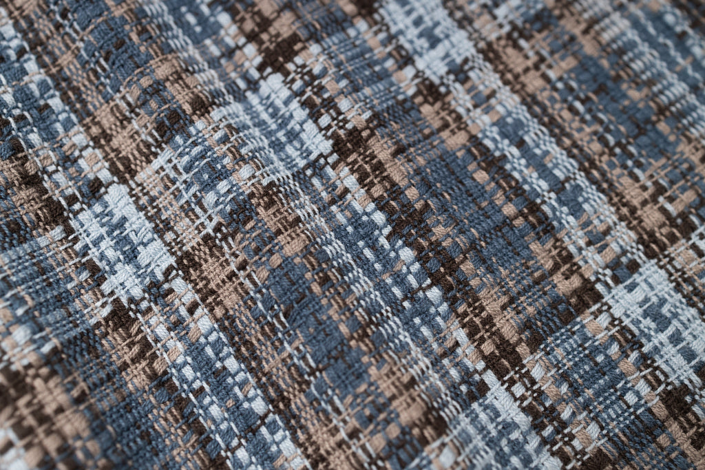 Close-up of a textured fabric with a checkered pattern in blue and brown.