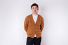 Man wearing a brown cardigan over a white shirt on a white background