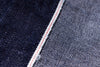 Close-up of denim fabric with a red thread seam