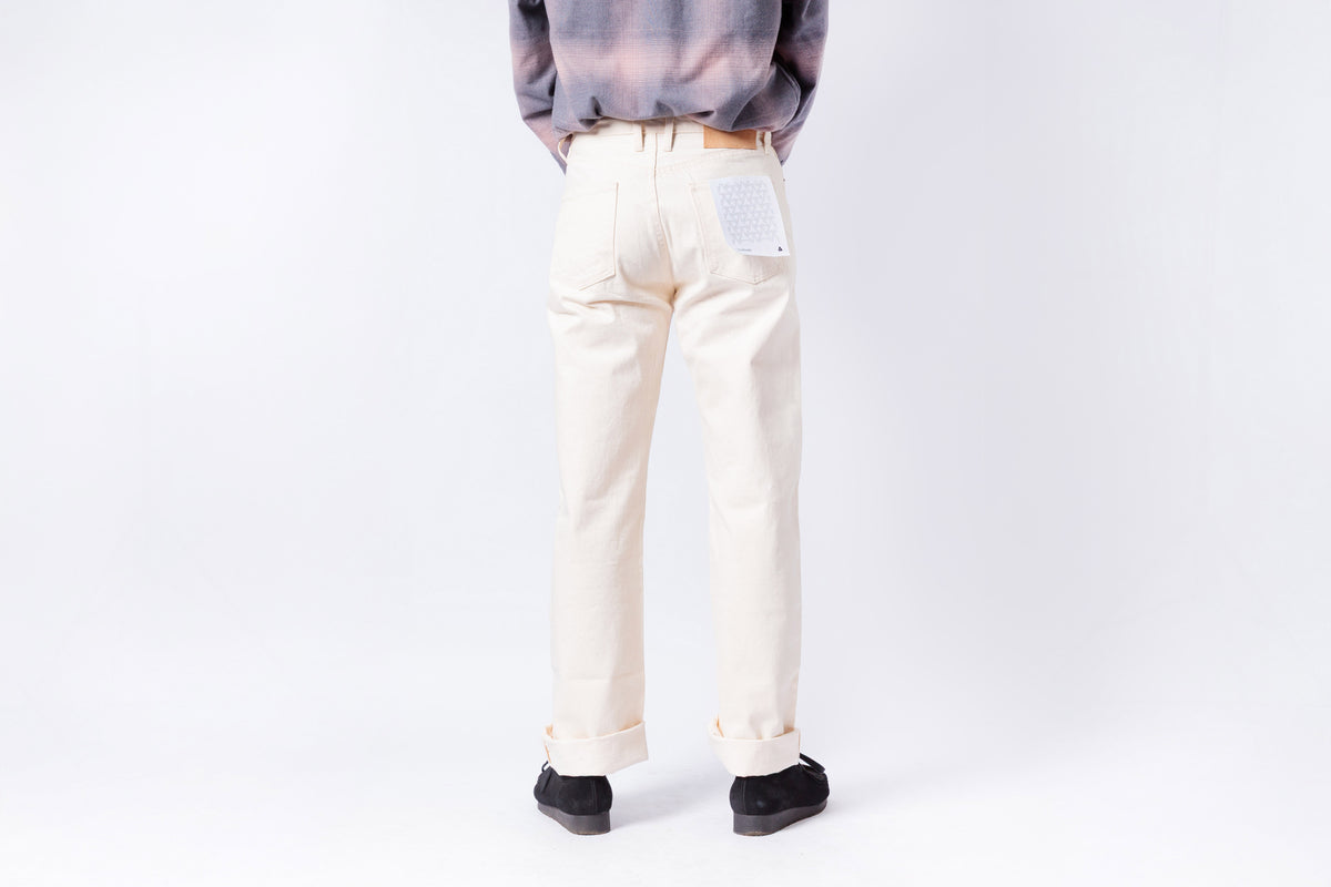 Person wearing light-colored pants and a gray top on a white background