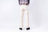 Person wearing light-colored pants and a gray top on a white background