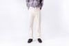 Person wearing a plaid shirt, beige pants, and black shoes on a white background