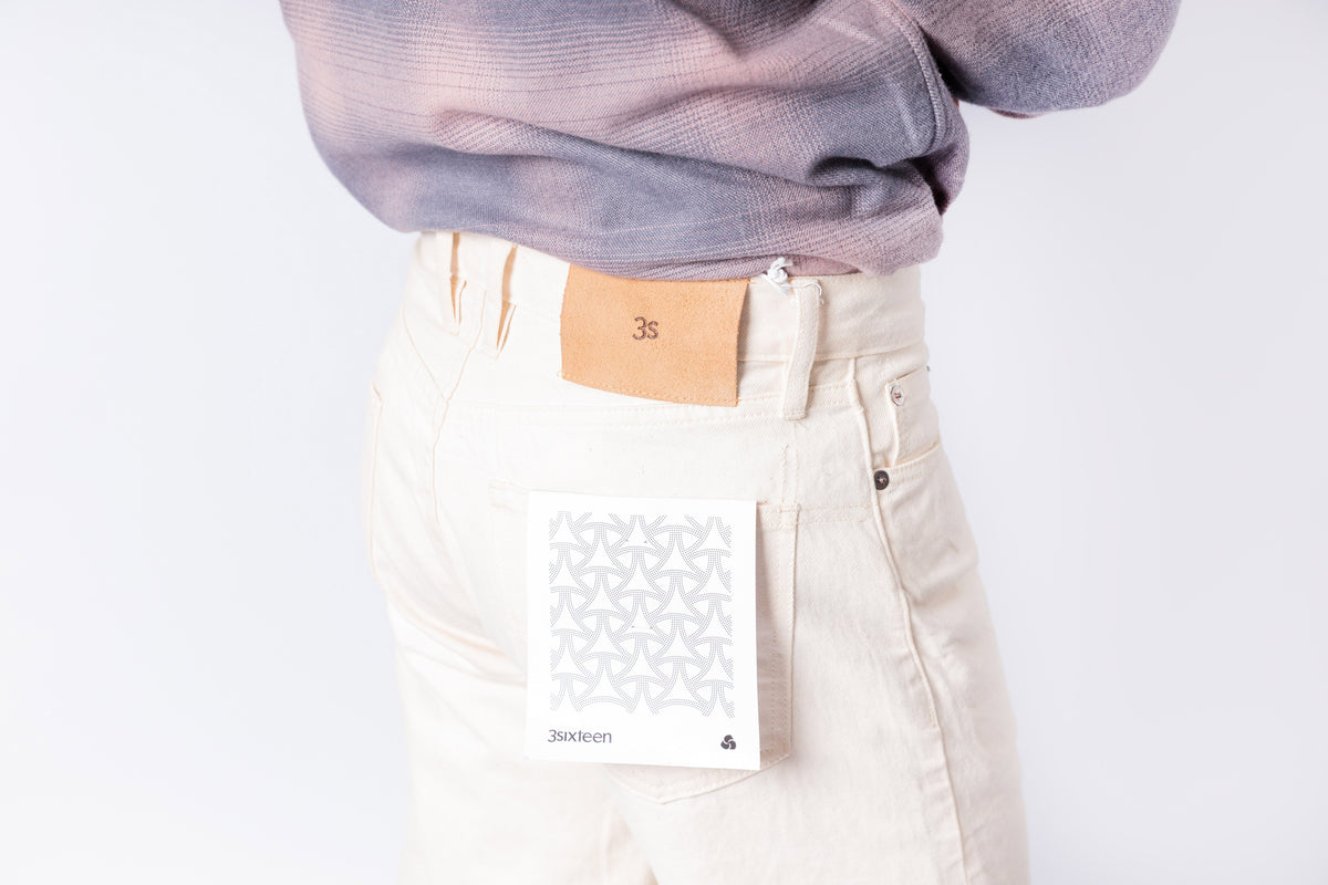 Person wearing a light purple sweater and beige pants on a white background