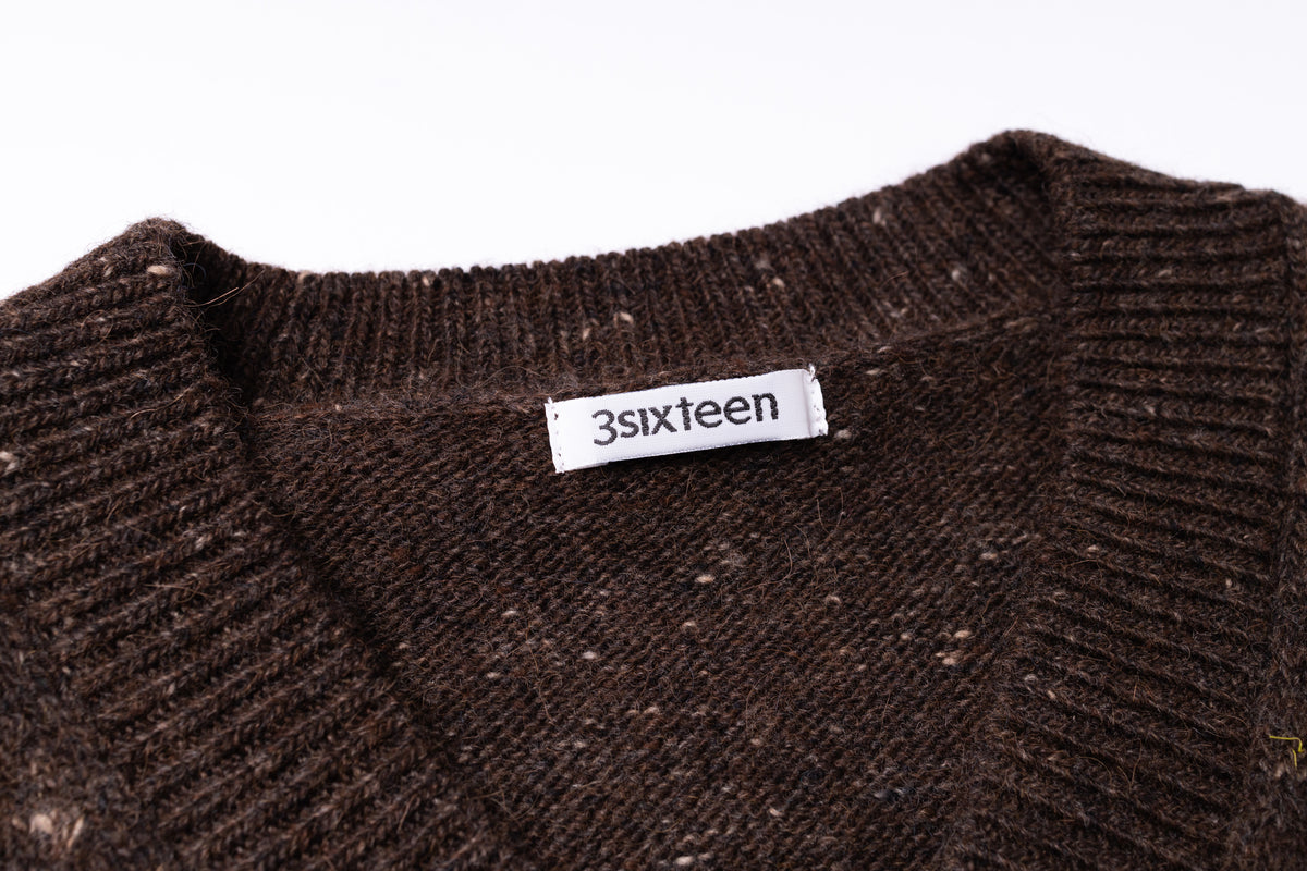Close-up of a dark brown ribbed knit sweater with a white brand label reading '3sixteen' visible at the collar, against a plain white background.