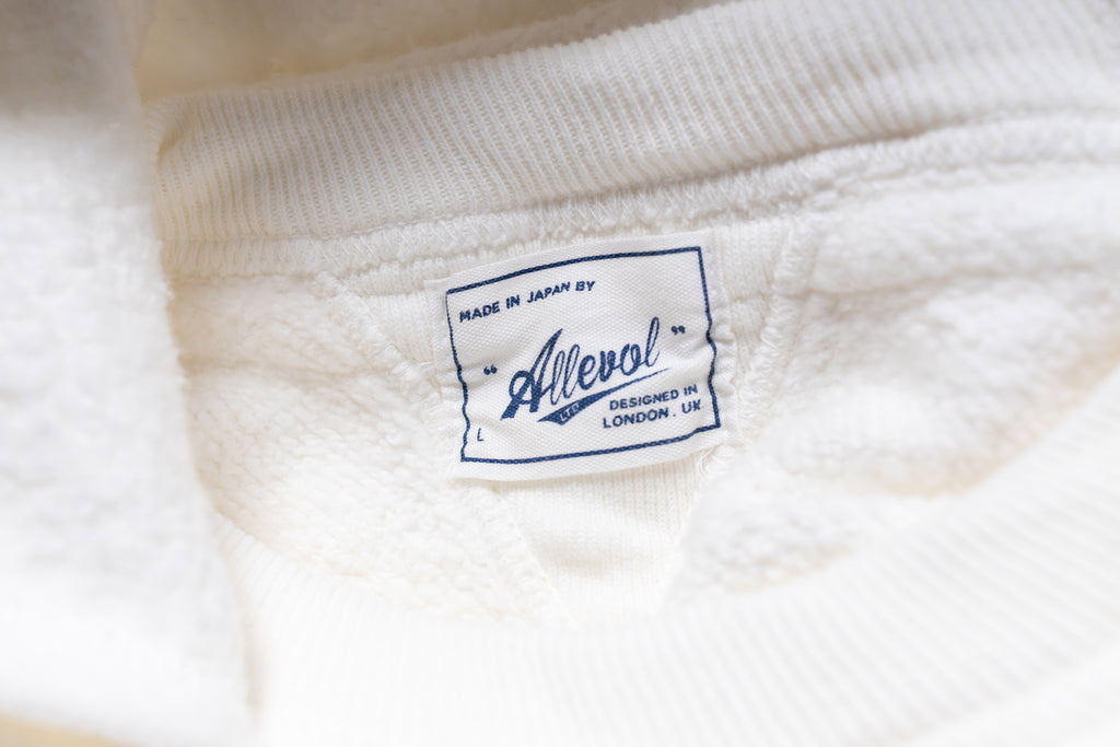 Close-up of a white fabric with a brand label on it.