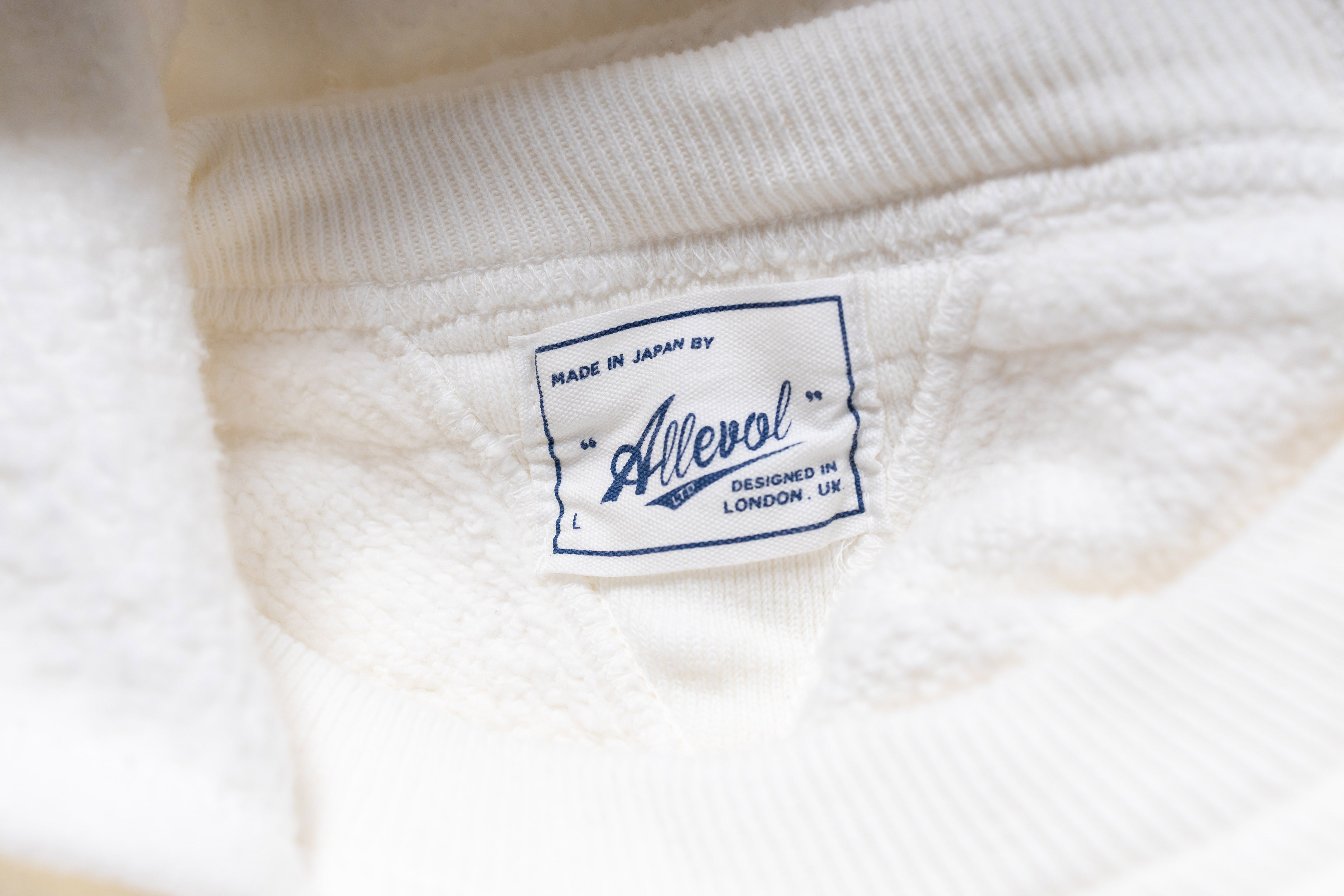 Close-up of a white fabric with a brand label on it.
