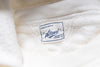Close-up of a white fabric with a brand label on it.