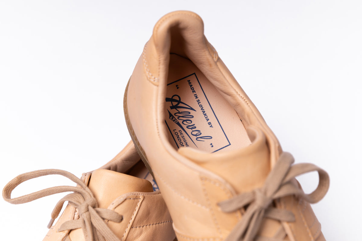 A close-up of a tan leather lace-up shoe shown from the side and top, with the brand name 'Allevol' visible on the inner label, set against a plain white background.