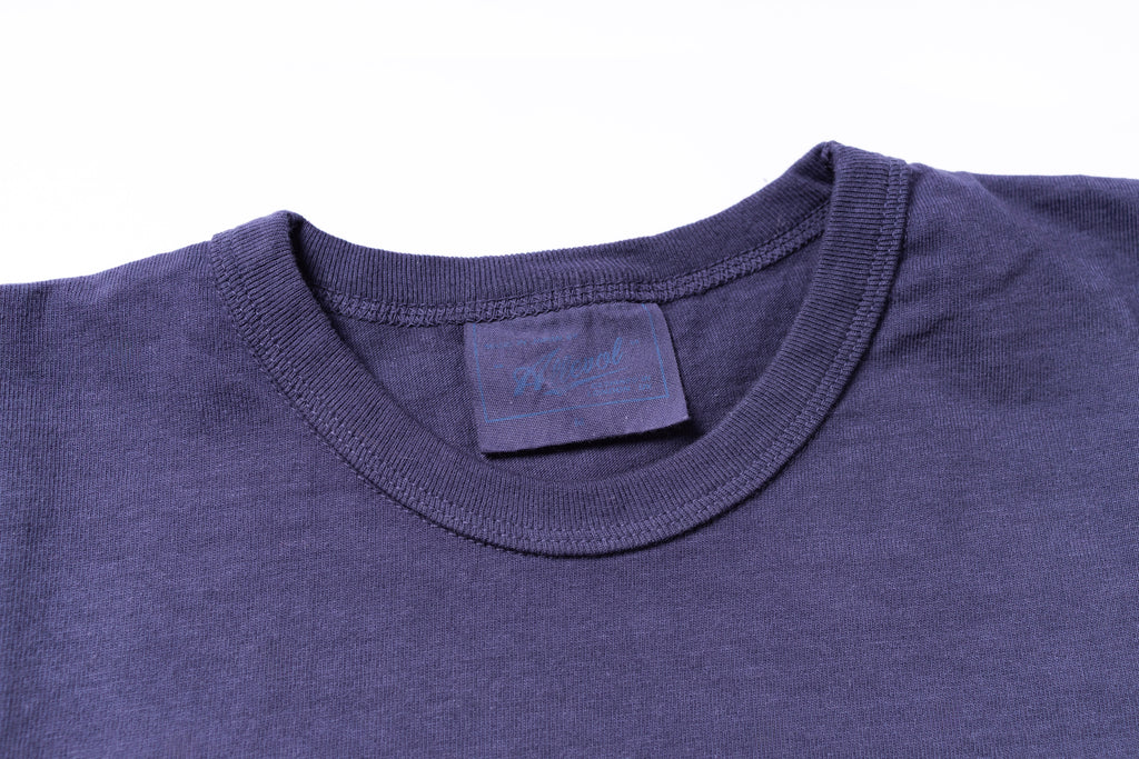 Close-up of a blue t-shirt collar with a brand label on a white background