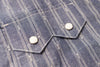 Close-up of a blue checkered shirt with buttons on a textured fabric background