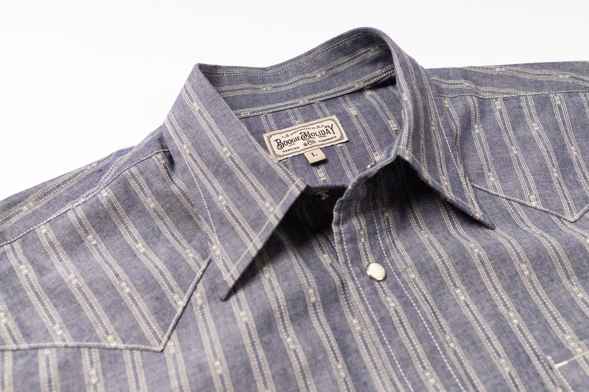 Close-up of a striped shirt with a brand label on a white background