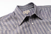 Close-up of a striped shirt with a brand label on a white background