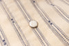 Close-up of a button on a striped fabric shirt