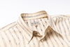 Beige striped shirt with a brand label on a white background