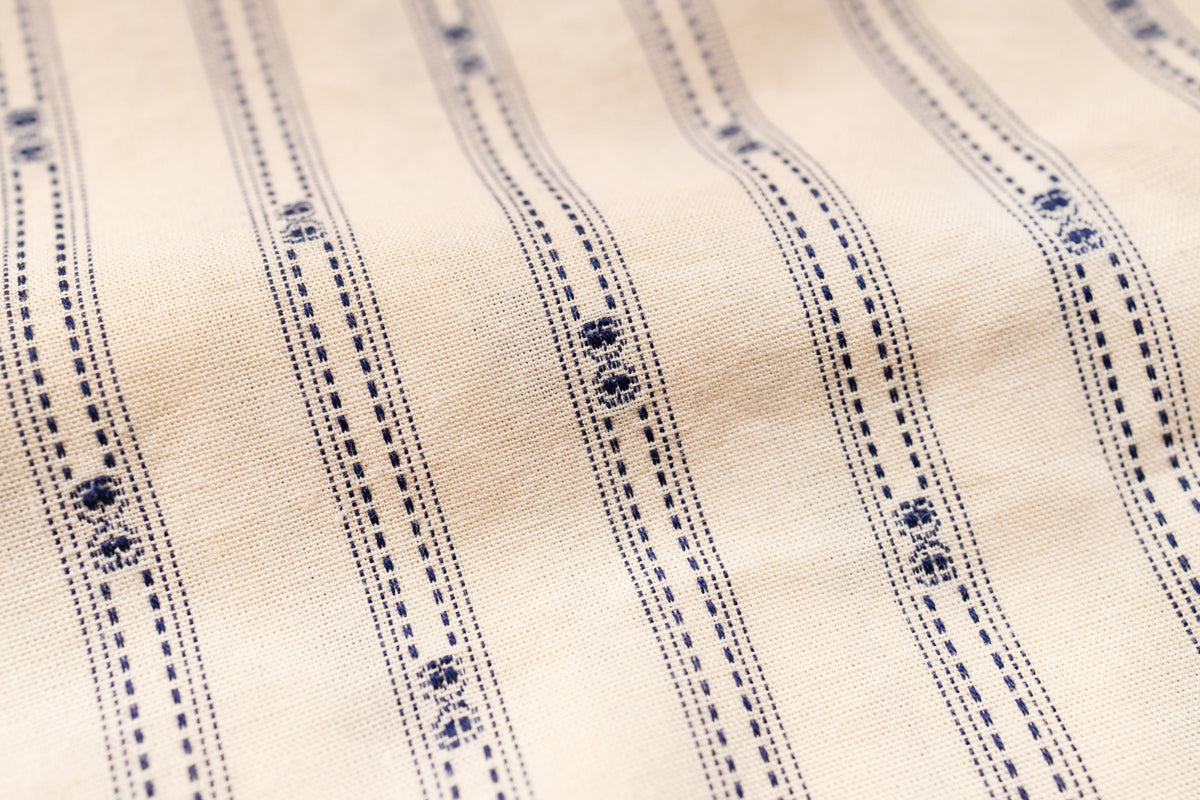 Close-up of beige fabric with blue embroidery