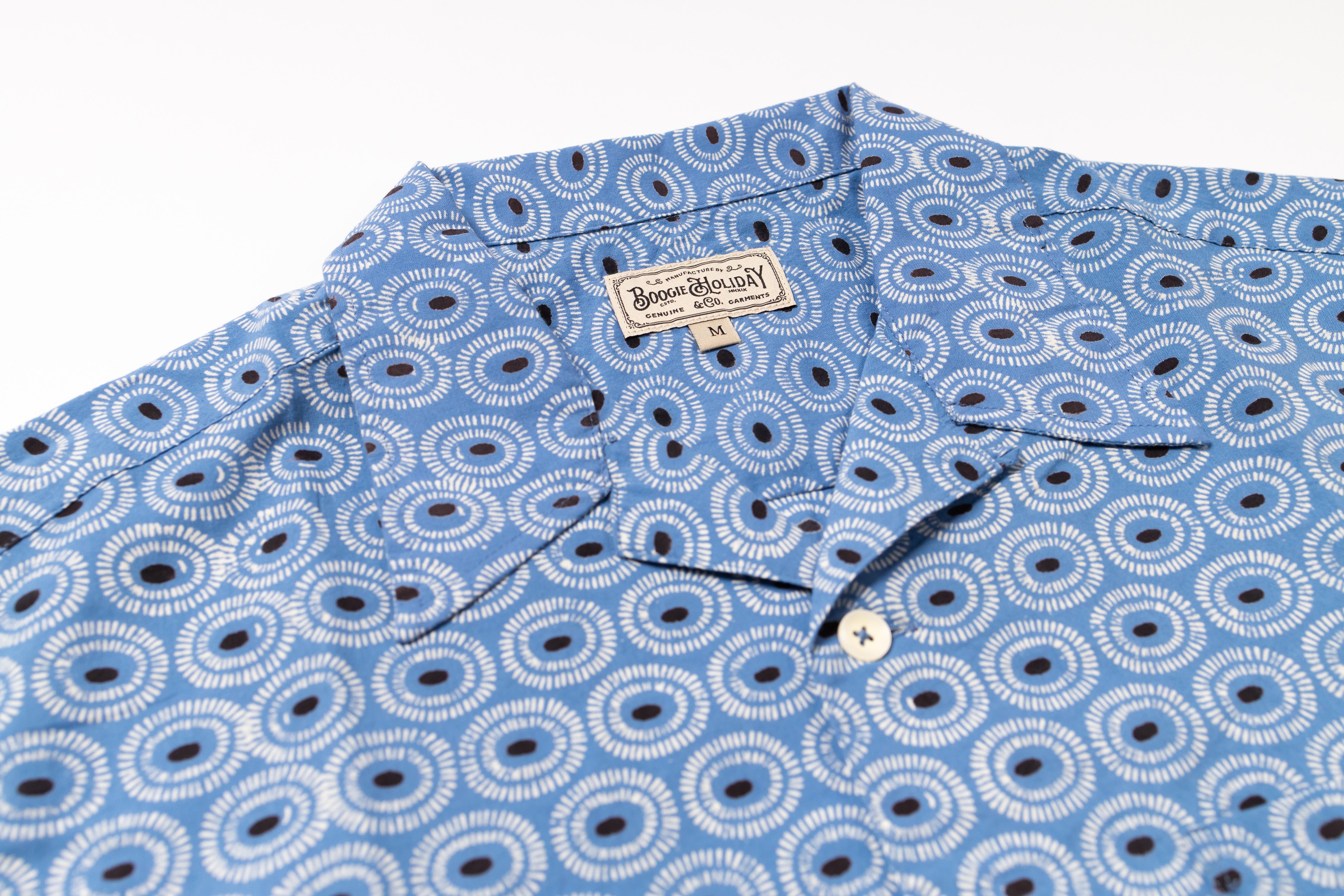 Blue patterned shirt with a brand label on a white background