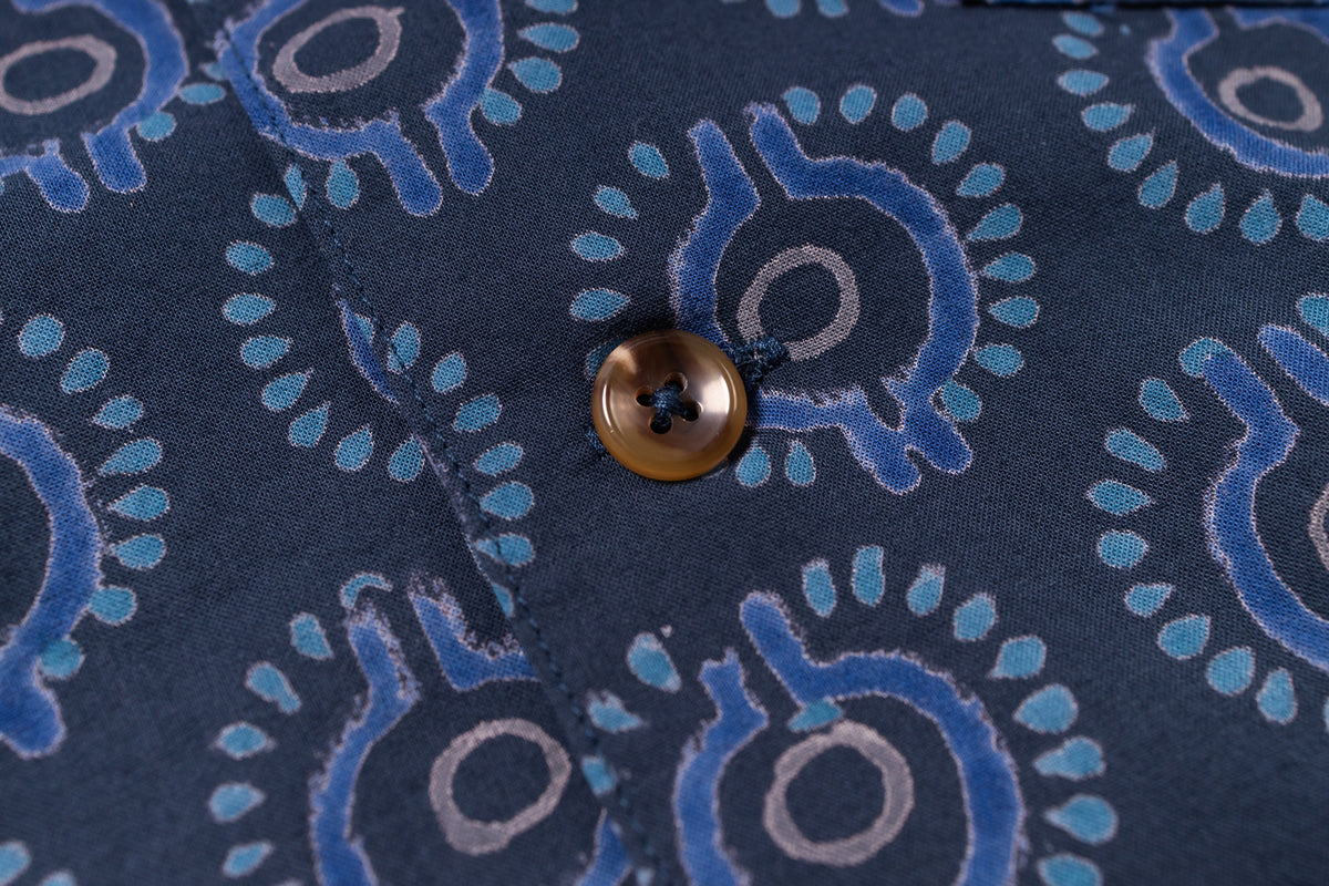 Close-up of a button on a fabric with blue and gray pattern