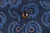 Close-up of a button on a fabric with blue and gray pattern